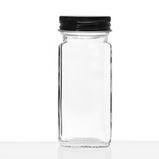 An empty clear glass jar in front of a white background.