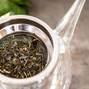 Licorice root herbs being steeped in a clear glass teapot