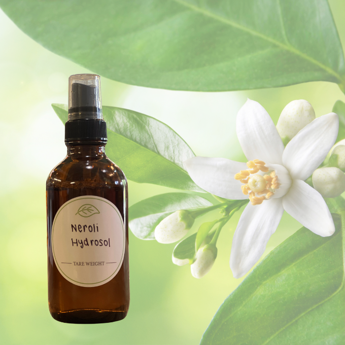Neroli hydrosol in glass sprayer with neroli flower background