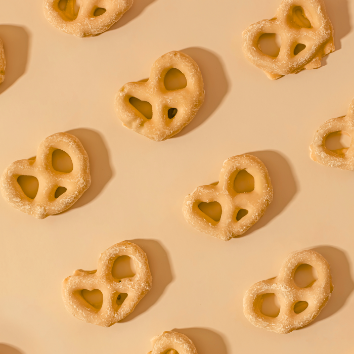 Peanut butter pretzels arranged on a plain background