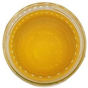A white background with a clear glass jar filled with apple cider vinegar