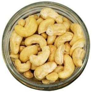 White background with a glass jar filled with Whole Cashews.