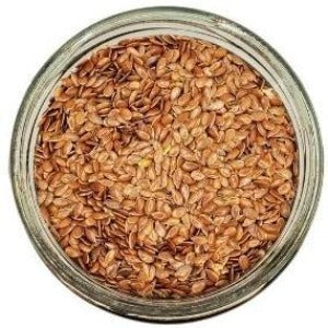 White background with a glass jar filled with Brown Flax Seeds.