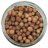 White background with a glass jar filled with Organic Whole Allspice.