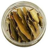 White background with a glass jar filled with Bay Leaves.