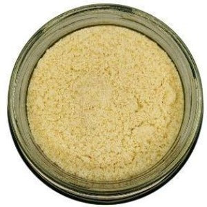 White background with a glass jar filled with Blanched Almond Flour.